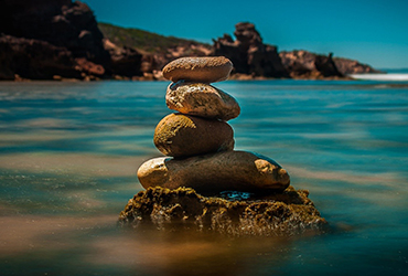 Four Stacked Stones on Ocean Water